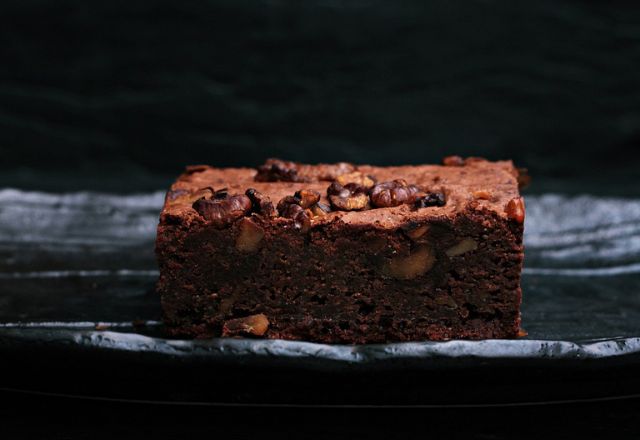 Brownie americano com nozes tostadas, em cima da mesa.