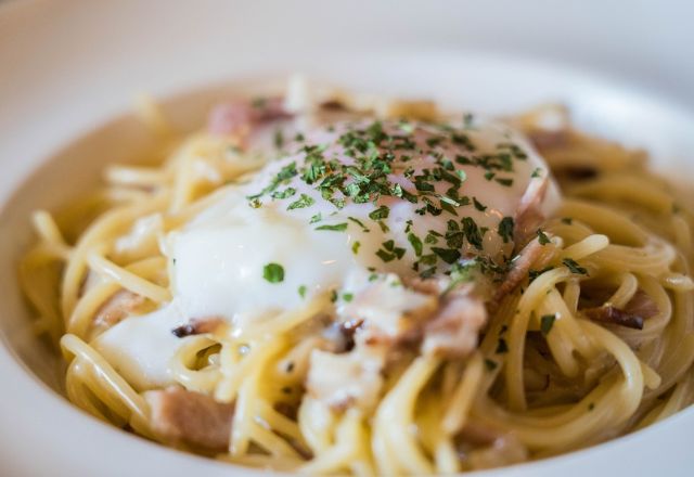 Macarrão a carbonara ao creme de leite, em prato de louça.